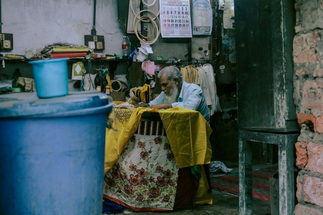 A tailor carefully working on a custom suit garment